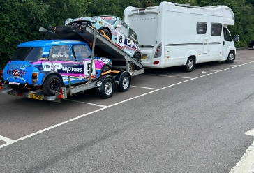 Image of racing cars being towed by a motorhome